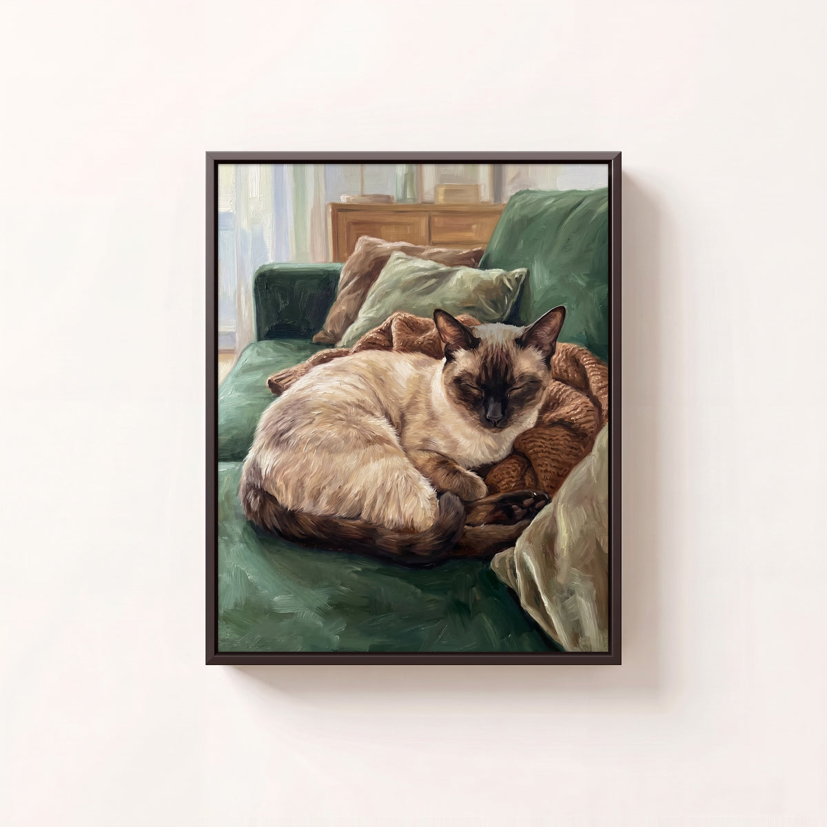 Cozy at Home oil portrait of a Siamese cat curled on a green sofa, black frame on a white wall